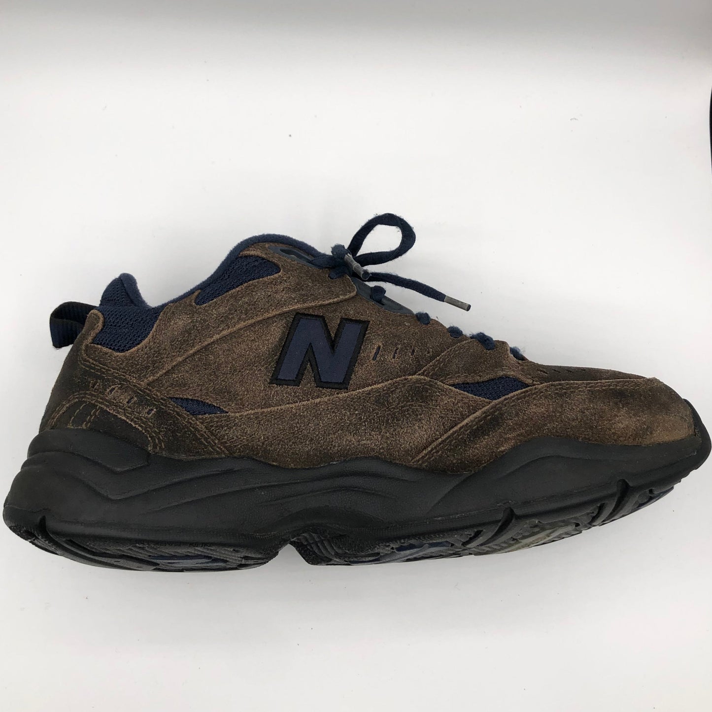 Brown sneaker with black accents on a white background