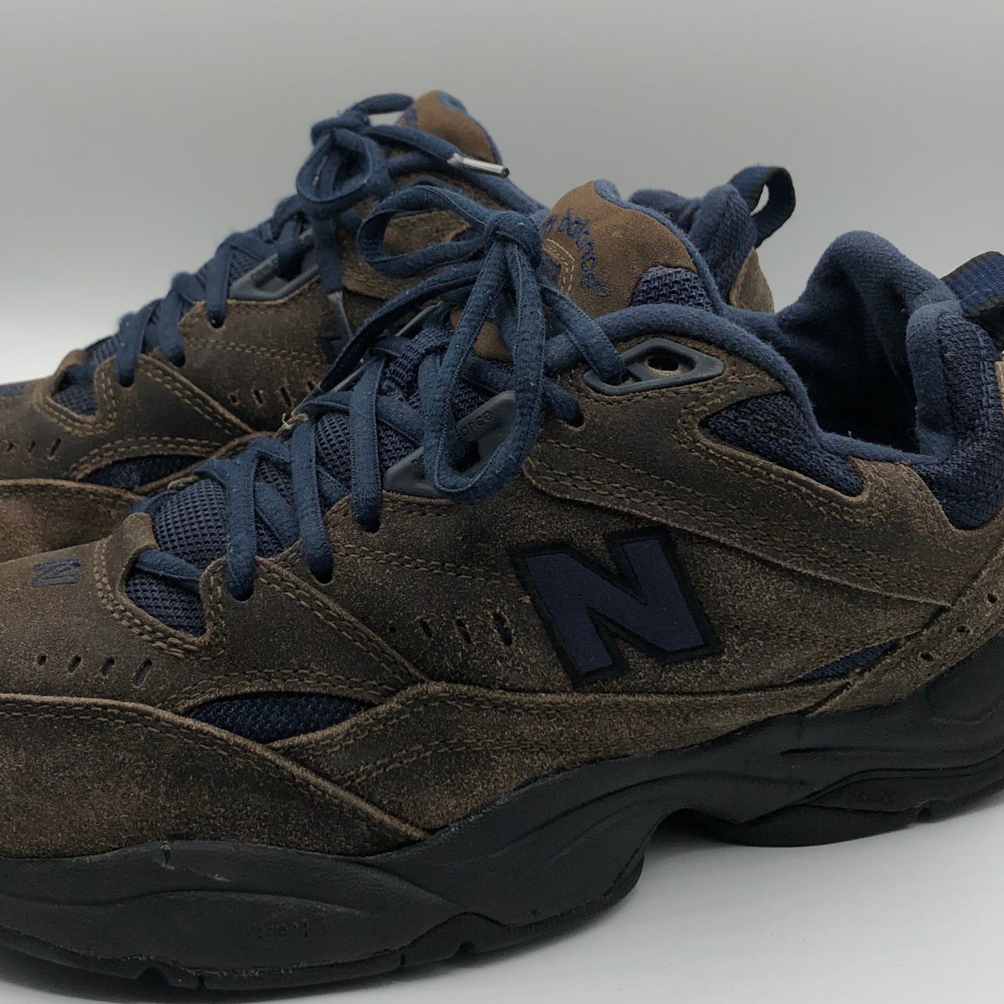 Brown sneakers with blue laces on a white background